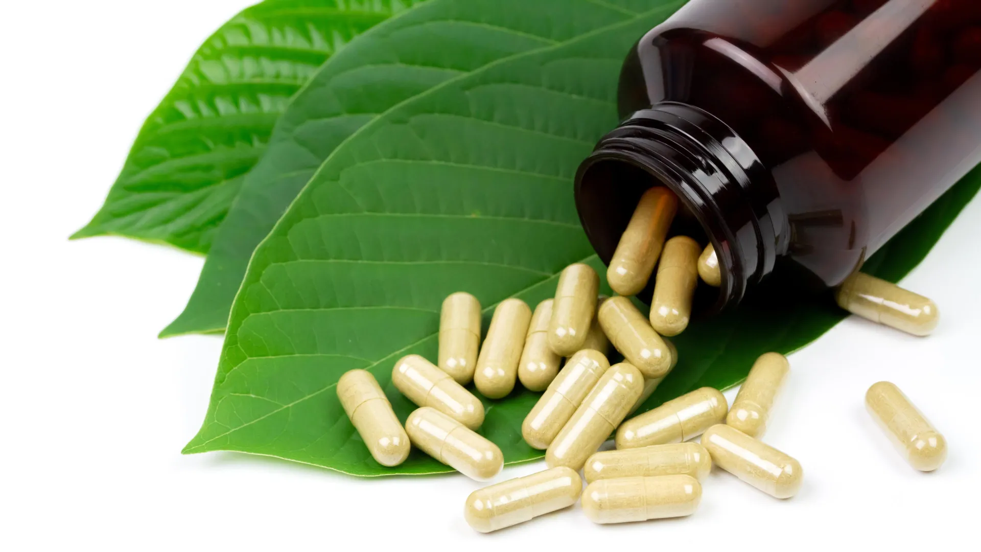 kratom-capsules-on-green-leaves-1 The Dark Side of the Kratom Boom